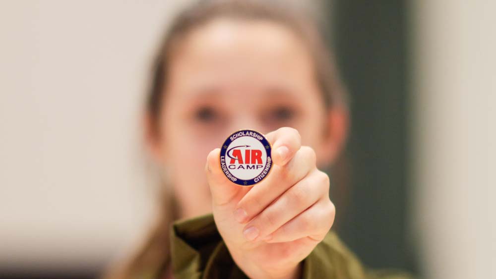 air camp student holding an air camp button pin