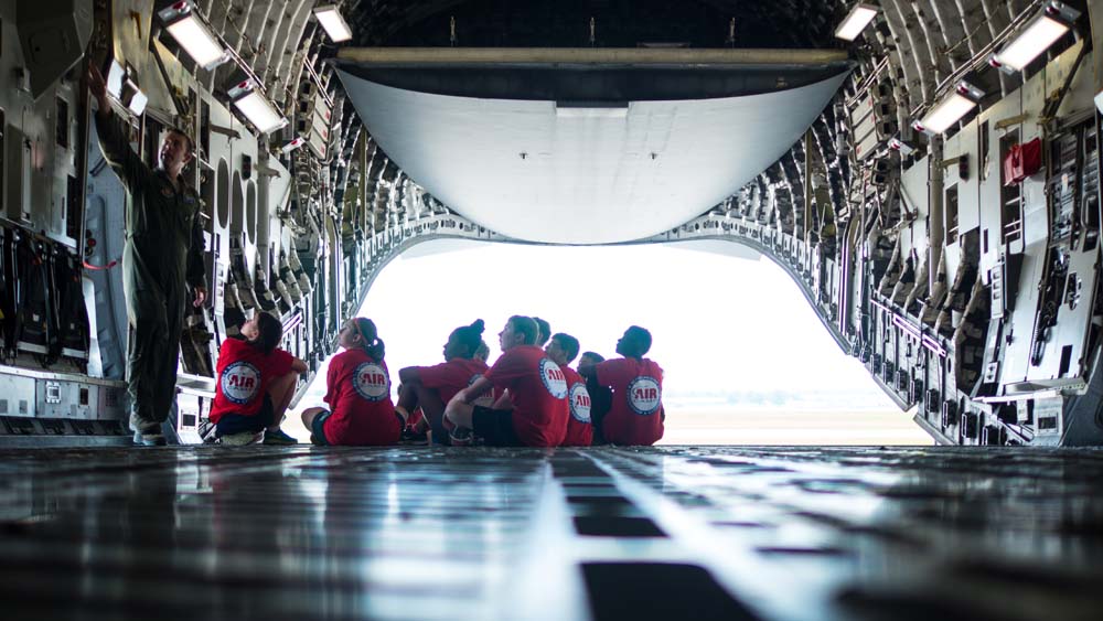 air camp students in storage area of a large plane