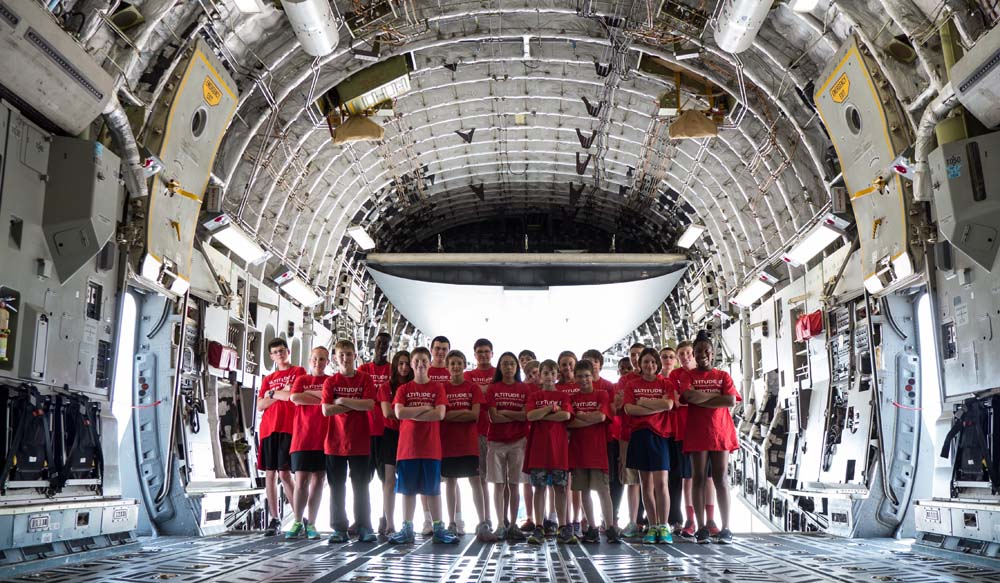 air camp students in storage area of a large plane