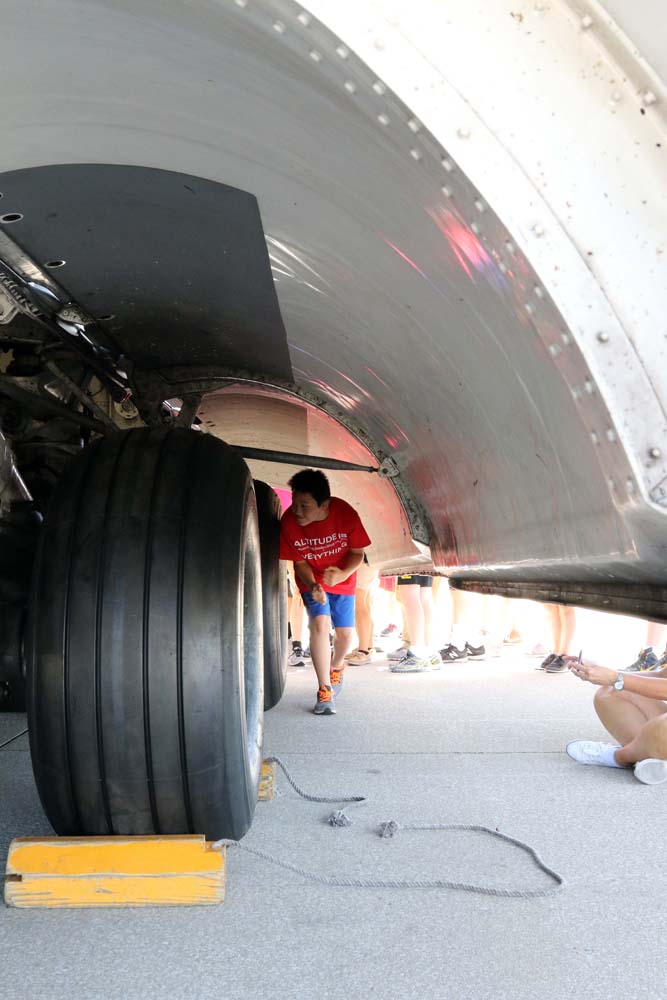 student under an airplane wheel shield