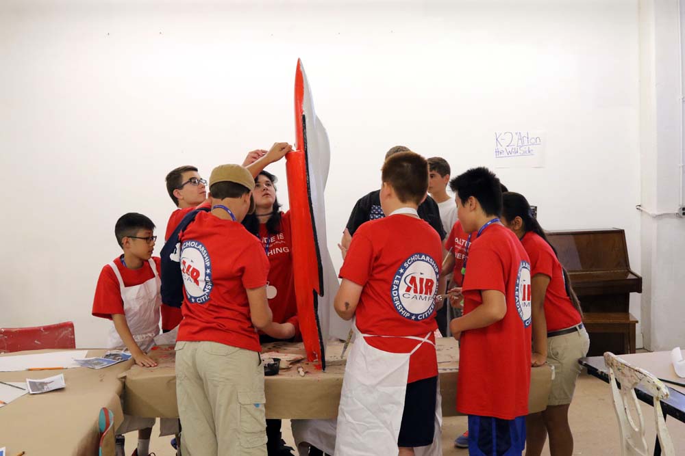 students in a group painting plane models