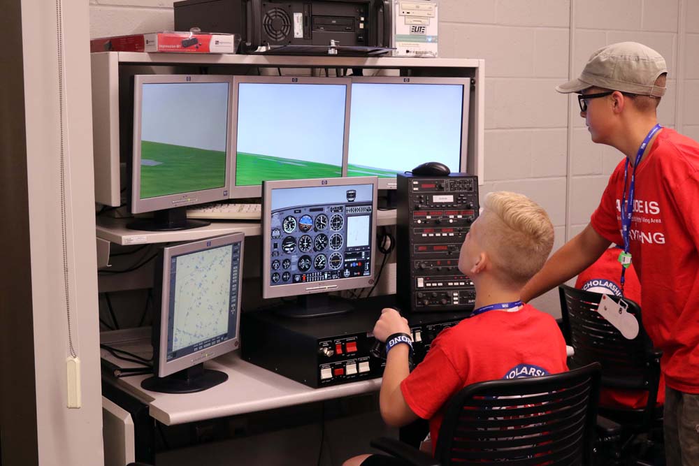air camp students using an aviation simulator