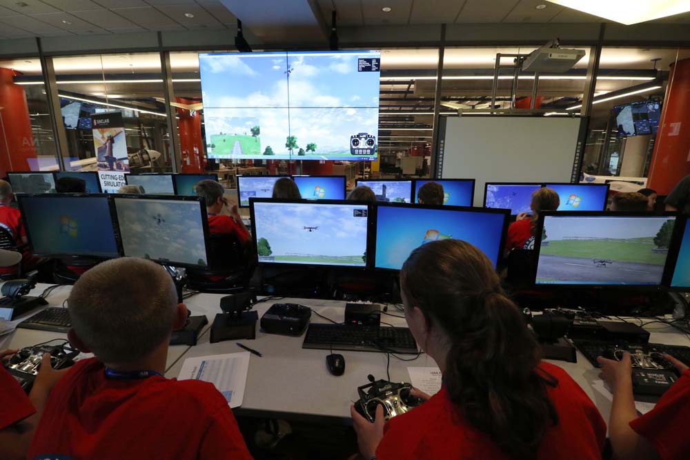 air camp students using an aviation simulator