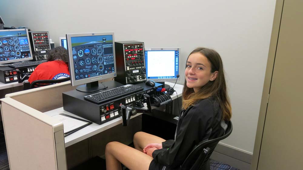 air camp students using an aviation simulator