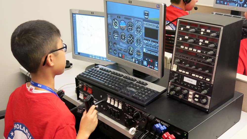 air camp students using an aviation simulator