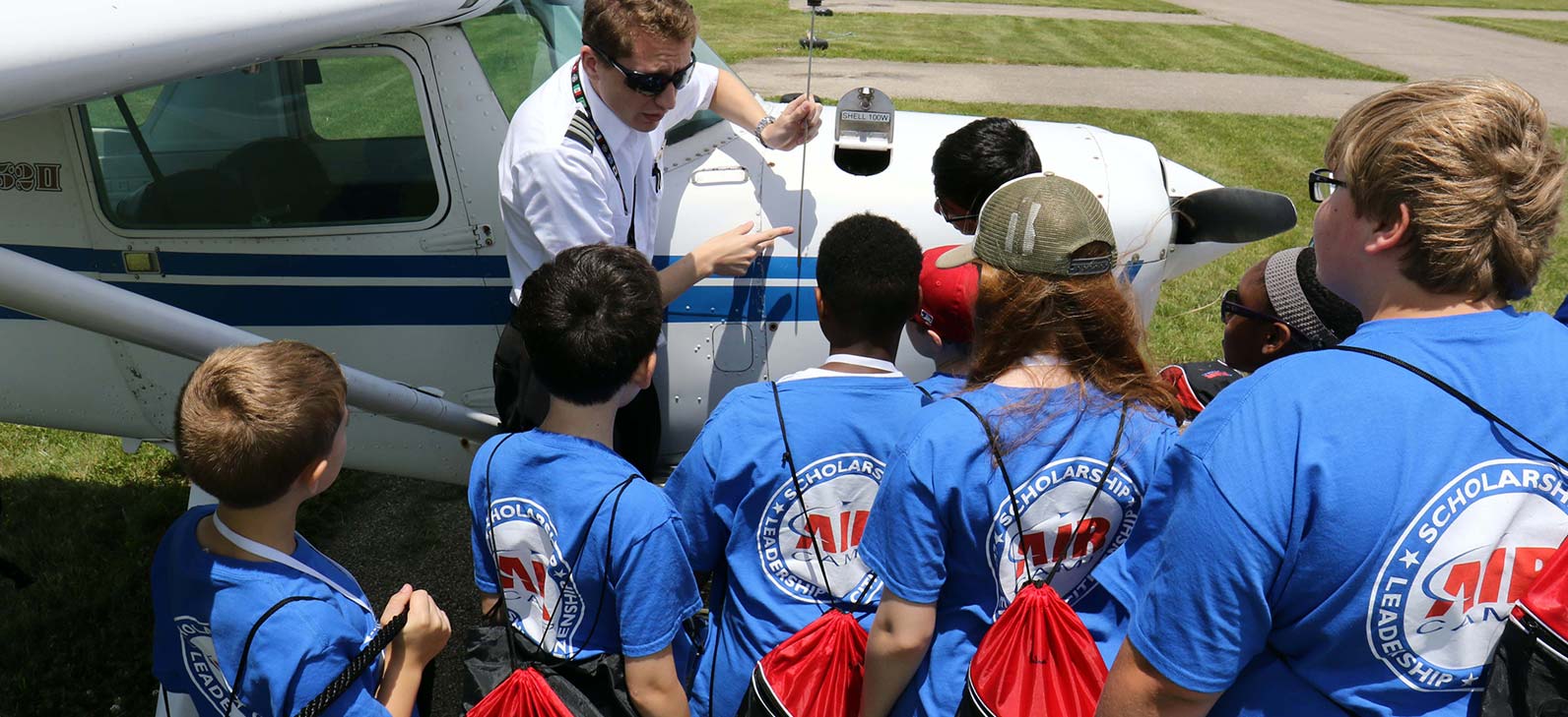 pilot explaining plane to group of kids